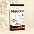 Migatto Junior 0.1 Rich in Natural Chicken 400 g dry cat food bag, front-dominant with a slim left side on a warm cream background with soft leaf shadows